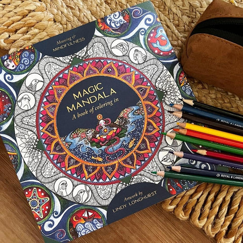 Spalvinimo knyga Magic Mandala su pusiau nuspalvintu mandalos viršeliu, šalia spalvotų pieštukų