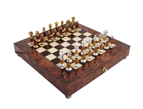 Šachmatų rinkinys mediniame lakuotame dėkle su auksinėmis ir sidabrinėmis metalinėmis figūromis, fotografuota iš viršaus kampu, parodytas uždarytas stalčius