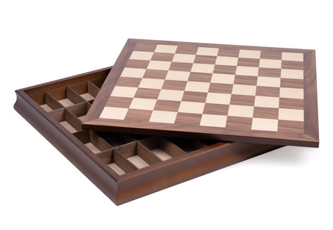 Šachmatų lenta iš riešuto medžio su šviesiomis laukelėmis, rodoma iš viršaus su atidarytu stalčiu ir skyreliais figūroms