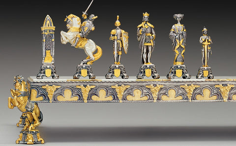Šachmatų figūros prabangi auksu ir sidabru padengta kolekcija ant lentos krašto, akcentuotos karaliaus ir riterio detalėmis