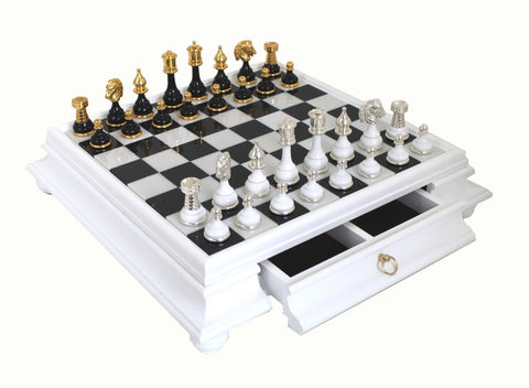 Šachmatai su balta lakine lente ir stalčiumi, su aukso ir sidabro metalinėmis figūromis, rodoma iš viršaus dešinės