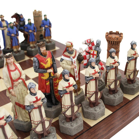Šachmatų rinkinys su viduramžių figūrėlėmis: artimas kampas, kreminės ir raudonos karališkos figūros ant tamsios medinės lentos