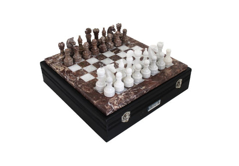 Šachmatų rinkinys iš rudo ir balto marmuro ant juodo sulankstomo lagamino, parodytas kampu su išdėstytais figūromis