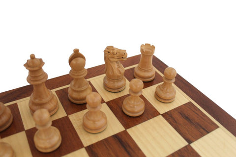 Šachmatai šviesiojo ėjimo figūros ant tamsaus ir šviesaus medinio 8x8 lentos kampo, artimas žirgo fokusas