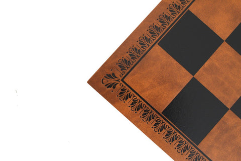 Šachmatų lenta ruda dirbtinė oda su juodomis kvadratinėmis aikštelėmis, kampinis artimas planas su ornamentiniu rėmu