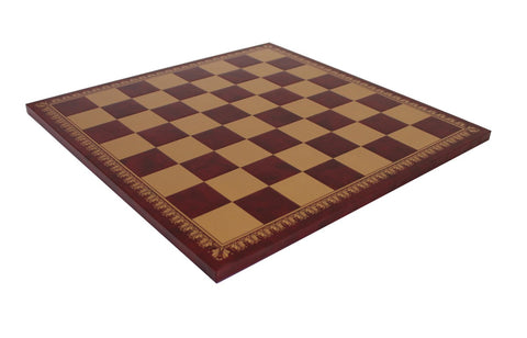 Šachmatų lenta tamsiai ruda su auksinėmis langeliais ir ornamentuotu auksiniu kraštu, parodyta pasvirusiu kampu dėl plono profilio