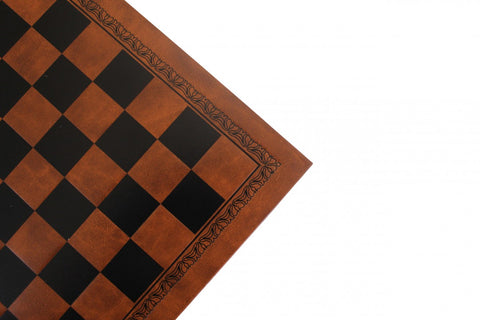 Šachmatų lenta ruda juoda dirbtinės odos, ornamentuotu kraštu ir žaidimo laukelio kampo artimas detalės rodinys