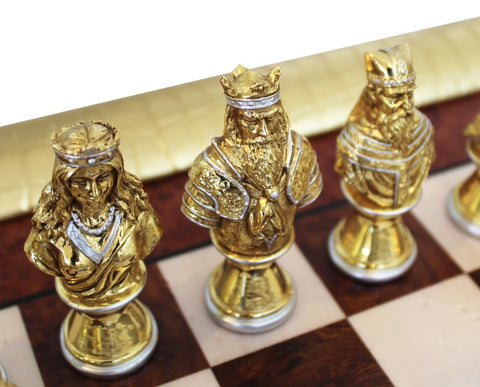 šachmatai – aukso spalvos metalinės karališkos figūros arti kadro, parodytos ant marmurinės ir medinės lentos