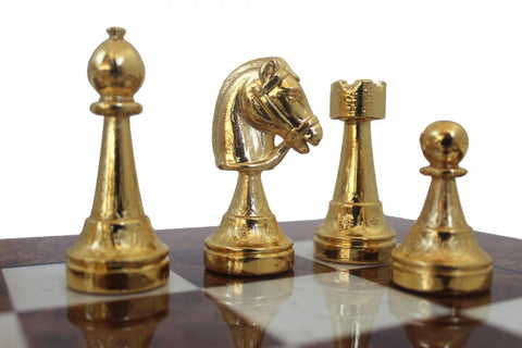 Šachmatų figūrėlės auksinės spalvos, artimas priekinis planas: vyskupas, raitelis, bokštas ir pėstininkas ant medinės lentos