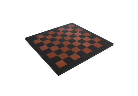 šachmatų lenta juoda su rudos spalvos langeliais, plonas medinis modelis, nufotografuota iš pasvirusio kampo