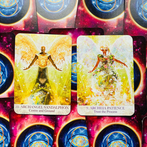 Orakulinės kortos su dviem atviromis geltonomis kortomis — Archangel Sandalphon ir Archeia Patience ant kosminio fono