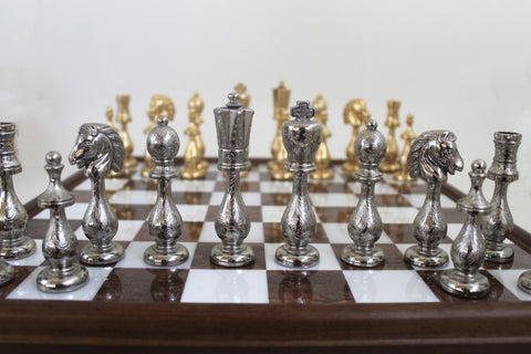 Šachmatai su sidabrinėmis metalinėmis figūromis priekyje ir auksinėmis už jų, medinė lenta su marmurinėmis langelėmis