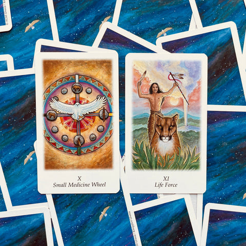 Tarot kortos iš rinkinio, dvi atviros kortos — Small Medicine Wheel ir Life Force, detalūs spalvoti piešiniai ant mėlyno žvaigždėto fono