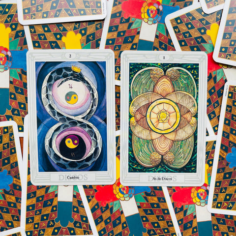 tarot kortos su dviem atvertais variantais — "Cambio" (mėlyni ir violetiniai tonai) ir "As de Discos" (žalios ir aukso detalės), plokščias komercinis išdėstymas, fokusas į piešinius