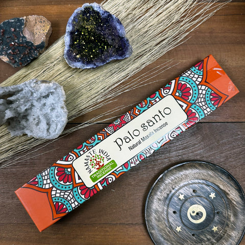 Palo santo smilkalai Namaste India oranžinė pakuotė, stilingai nufotografuota iš viršaus su laikikliu ir kristalais