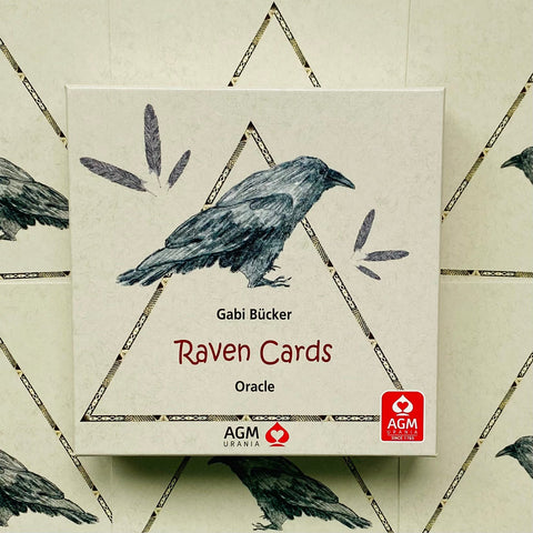 Raven Cards kortos – kreminė dėžutė su pieštu juodu varnu, AGM Urania logotipu ir trikampiu dizainu