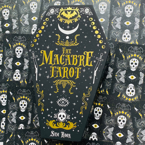 Tarot kortos The Macabre – juoda karsto formos dėžutė (Sam Rook) su auksinėmis ir baltomis okultinėmis dekoracijomis