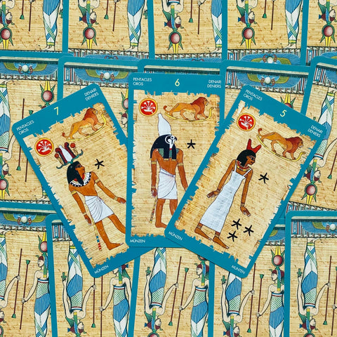 tarot kortos Egipto stiliaus su melsvais kraštais — trys Monetų rūšies kortos (5, 6, 7) parodytos priekiniais kampais, skiriasi nuo kitų galerijos kadrų