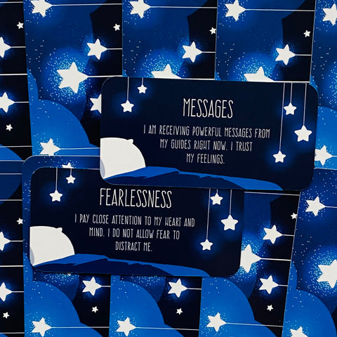 Affirmacijų kortos tamsiai mėlynos su žvaigždžių raštu, dvi išdėstytos sluoksniuotos kortelės su „Messages“ ir „Fearlessness“ tekstais