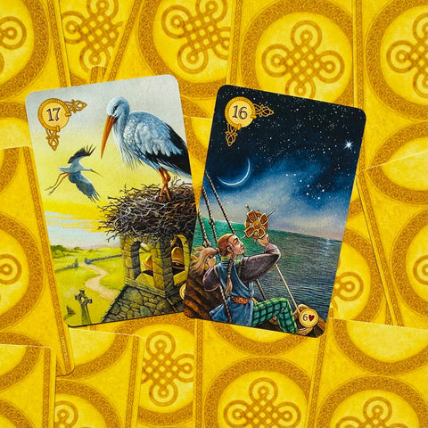 tarot kortos Little White Owl, dvi išskleistos kortos — 17 Gandras ir 16 Ratas, detaliai iliustruotos ant geltono galinio fono