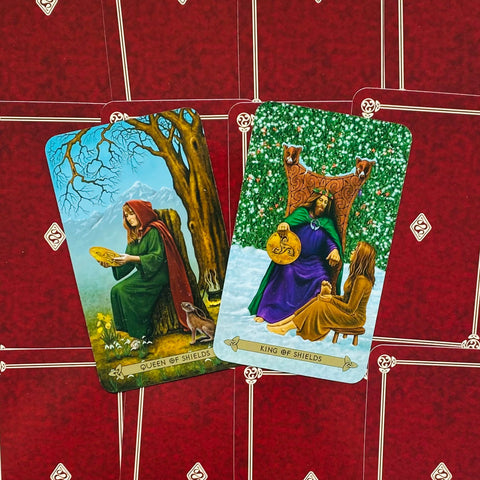Tarot kortos – kompozicija su Queen of Shields ir King of Shields, žali ir violetiniai rūbai ant raudono fono