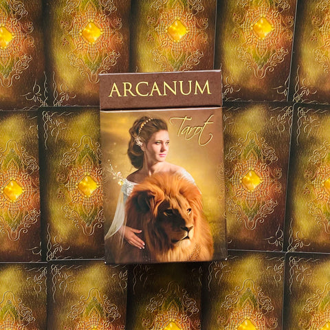 Tarot kortos Arcanum — rudos priekio pakuotės su moters ir liūto iliustracija, artimas kadras, skiriantis šią versiją nuo kitų galerijoje