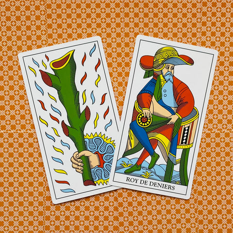tarot kortos Tarot de Marseille – atverstos vieneto kuolų ir monetų karaliaus kortos, padėtos pasvirusiomis ant oranžinio raštuoto audinio