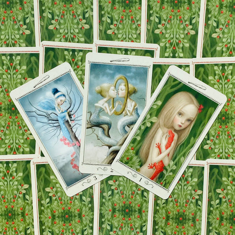 Tarot kortos su iliustruotais priekiais — trijų kortų kompozicija, dengianti žaliu nugarėlių raštu su raudonomis uogelėmis
