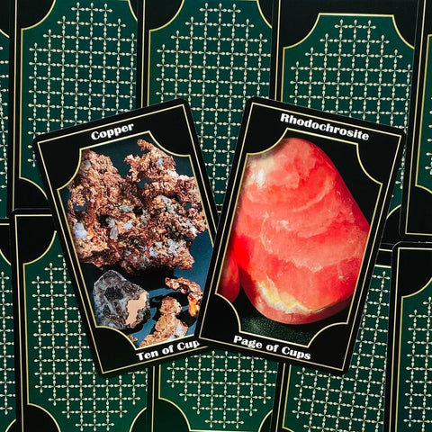 Tarot kortos su akmenų iliustracijomis, priekyje Copper ir Rhodochrosite kortos ant žalsvo raštuoto fono
