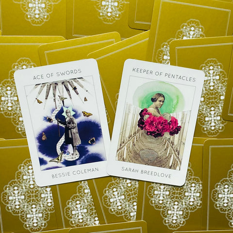 tarot kortos su baltomis priekėmis ir auksinėmis nugarėlėmis, dvi atverstos kortos Ace of Swords ir Keeper of Pentacles, fotografuota iš viršaus