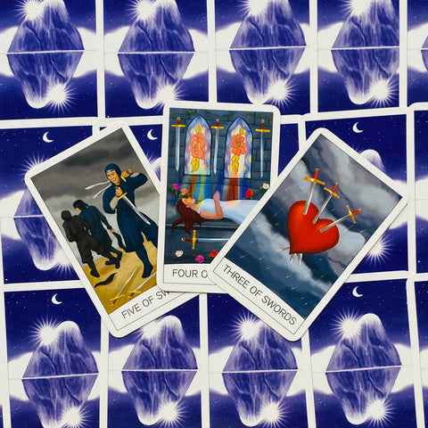 Tarot kortos Swords rinkinio: Three of Swords, Four of Swords ir Five of Swords išdėstytos ant mėlynos žvaigždėtos nugarėlės