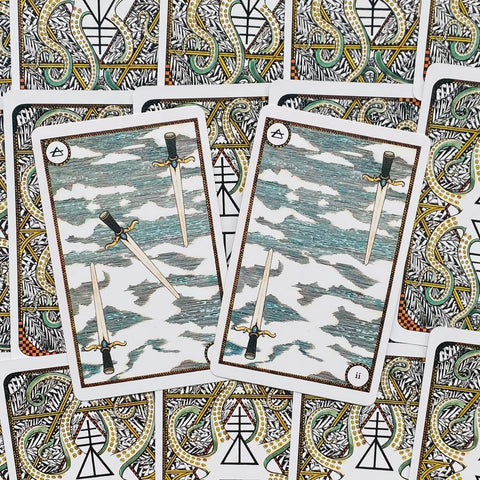 tarot kortos su kalavijų motyvais, dvi išdėstytos kortos centre ant ornamentinių nugarėlių fono