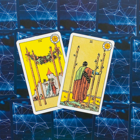 Tarot kortos Rider–Waite stiliaus: dvi geltonos lazdų kortos (IV ir III) atverstos ant mėlyno tinklinio galinio fono
