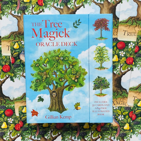 Prekės puslapyje: priekinė mėlyna The Tree Magick oracle kortų dėžutė (Gillian Kemp), matomas priekis ir šoninis skyrius su trimis medžių iliustracijomis ant raštuoto fono
