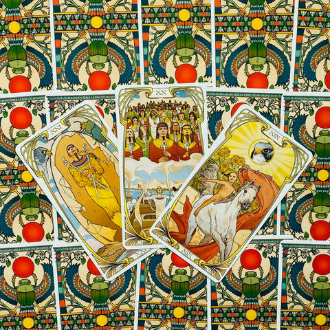 Tarot kortos egiptietiško dizaino, trys atverstos kortos fanuotos virš dekoratyvių nugarėlių, vaizduoja saulę, jūrą ir žirgą
