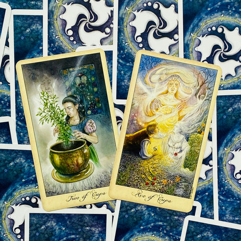 tarot kortos su mėlynu nugarėliu, dvi atviros kortos (Two of Cups ir Ace of Cups) parodytos iš arti, aiškūs piešiniai