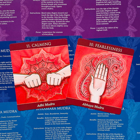 meditacinės kortos raudonos — dvi kortos Calming (Adhi Mudra) ir Fearlessness (Abhaya Mudra) ant mėlyno instrukcijų lapo