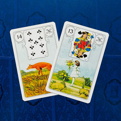 Lenormand kortos, dvi atverstos kortos — Lapė (ruda) ir Vaikas (balta suknelė) ant mėlyno fono, kampinis išdėstymas