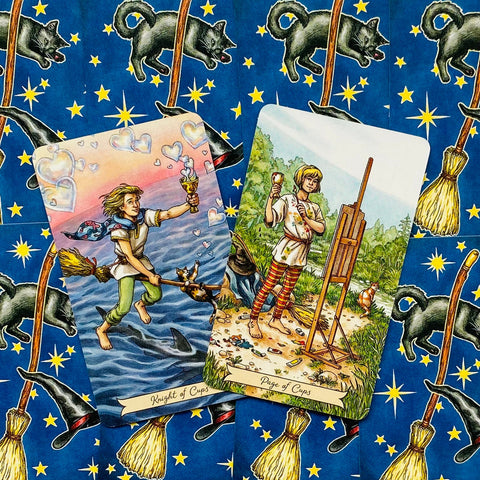 Tarot kortos su spalvotomis iliustracijomis — Knight of Cups ir Page of Cups ant mėlyno šluotų ir žvaigždžių fono