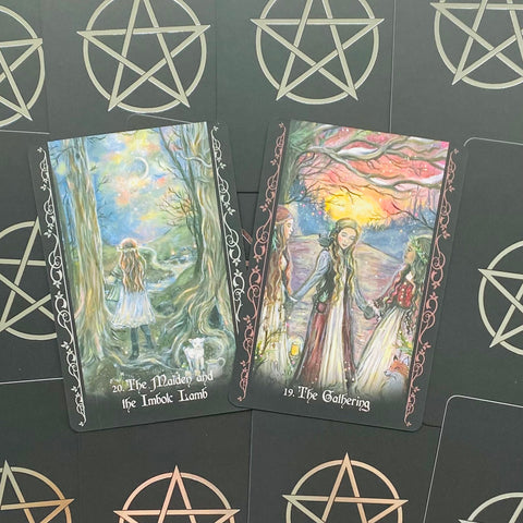 tarot kortos — dvi atverstos iliustruotos kortos (The Maiden and the Imbolc Lamb ir The Gathering) ant juodo fono su pentagramomis