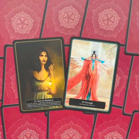 Tarot kortos atverstos dviem kortomis: moters su žibintu ir sparnuotos raudonos figūros, padėtos ant rožinių nugarėlių fono