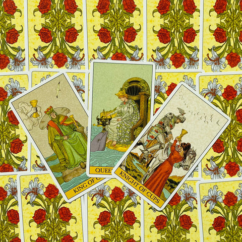 tarot kortos Rider‑Waite stiliaus, trijų taurų karališkųjų kortų išdėstymas (Karalius, Karalienė, Riteris) ant geltonos gėlių nugarėlės