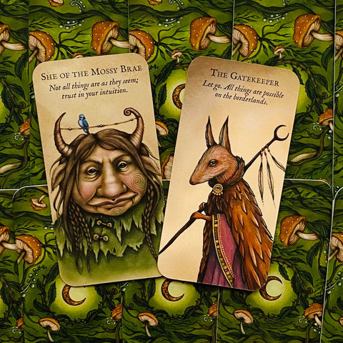 Orakulo kortos: dvi priekio kortos – She of the Mossy Brae ir The Gatekeeper, smulkiai iliustruotos ant žalių grybų nugarėlių
