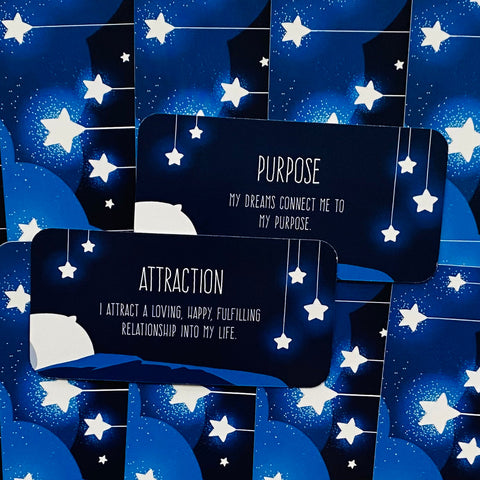 Afirmacijų kortelės su tamsiai mėlynu žvaigždžių dizainu — dvi kortelės Attraction ir Purpose priekinės pusės, tinkamos nakties ritualams