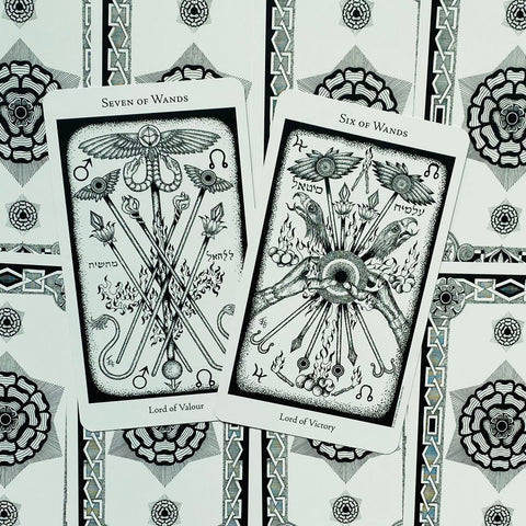 Taro kortos juodai baltos, dvi atverstos kortos (Seven of Wands ir Six of Wands) ant ornamentinės kortų nugarėlės