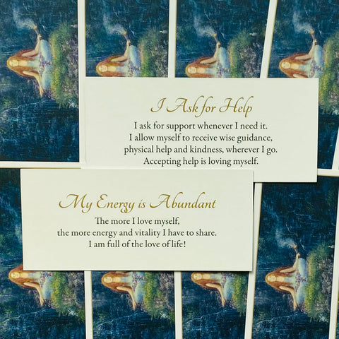 Afirmacijos kortelės su kreminiu fonu ir angliškais tekstais „I Ask for Help“ ir „My Energy is Abundant“, artimas kadras rodantis švelnų dizainą