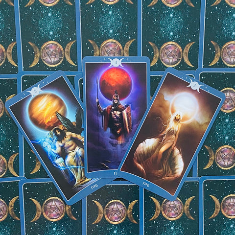 Tarot kortos trijų atvirų kortų išklotyje su mėlytomis kraštinėmis, ugnies elementais ir mėlyna nugarėle