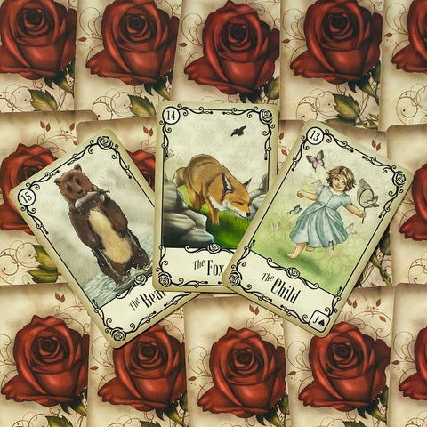 Lenormand kortos – trijų kortų išklotinė (Lokys, Lapė, Vaikas) ant raudonų rožių nugarėlių, rodoma kaip variantas