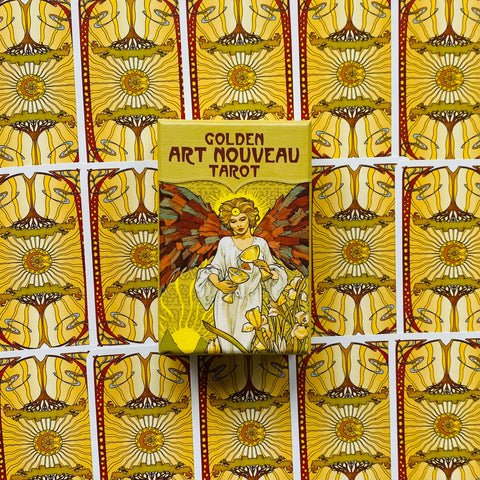 Produkto puslapis — Golden Art Nouveau Tarot geltona dėžutė (priekinis vaizdas) ant kortų nugarėlių rašto