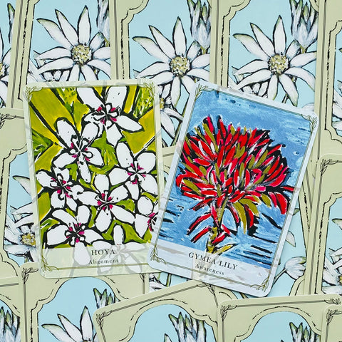 Kortos botaninių orakulo kortų: dvi atvertos Hoya (žalia) ir Gymea Lily (raudona) ant dekoratyvių nugarėlių